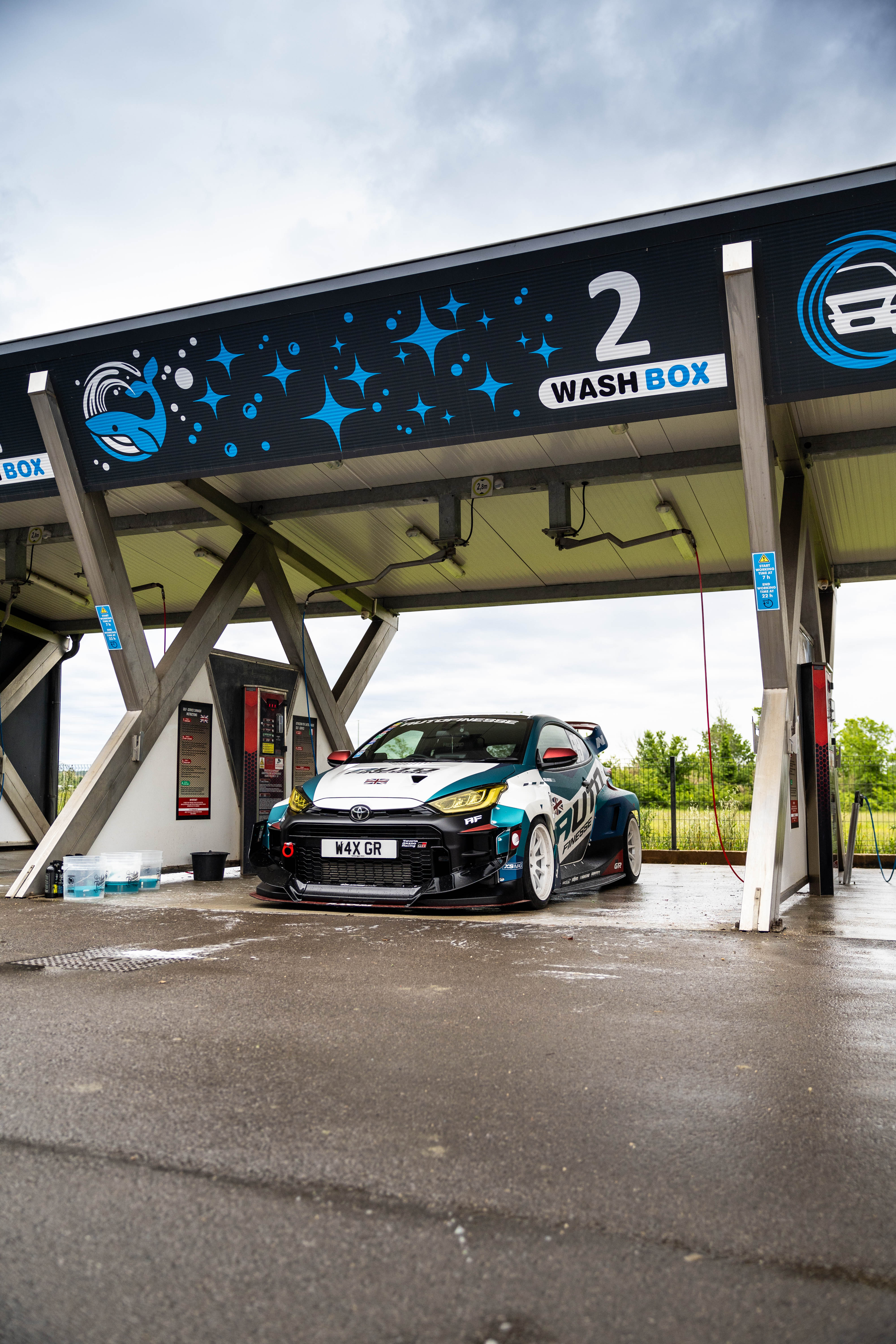 Car at a car wash station with 'Wash Box' branding.