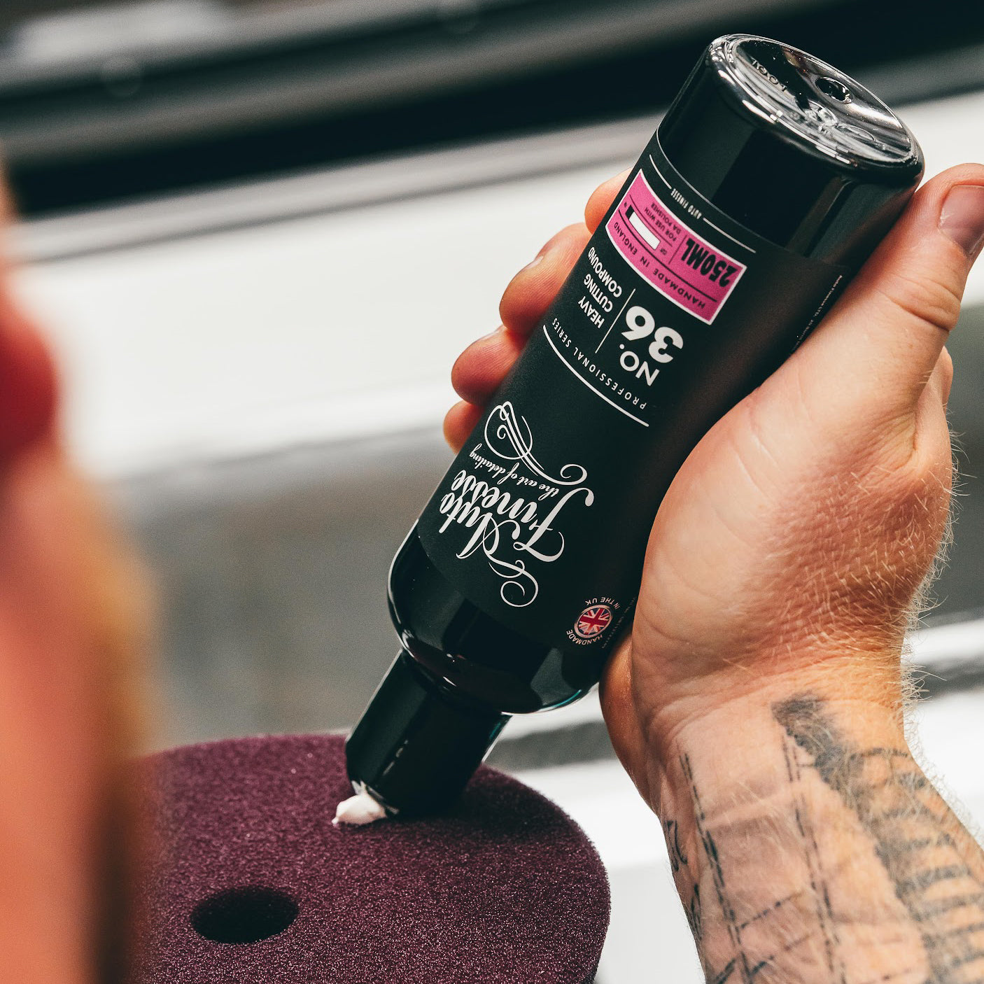 Hand holding a can of hair product with visible branding