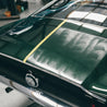 Close-up of a green car with a yellow stripe in a garage setting