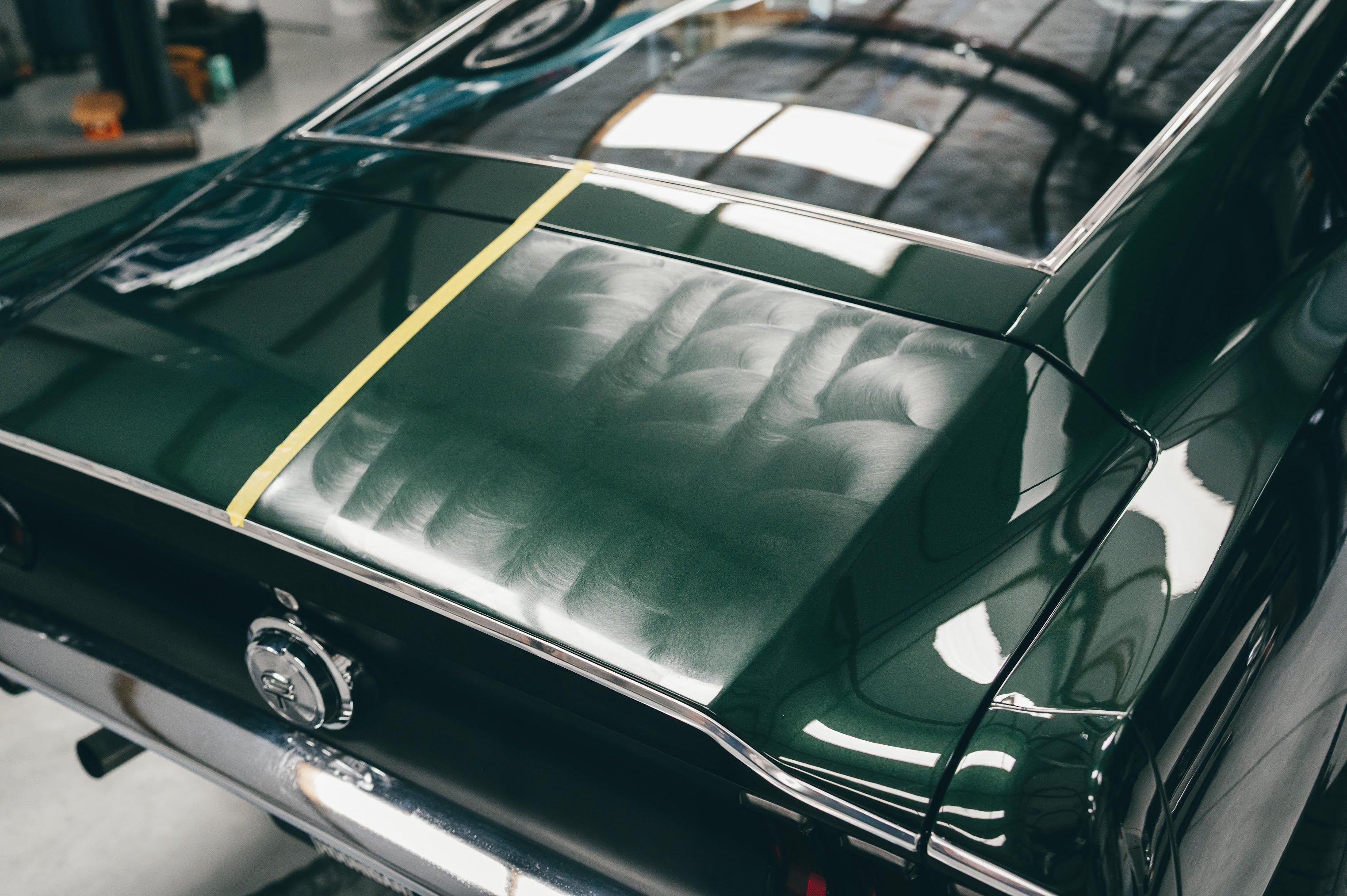 Close-up of a green car with a logo on a blurred background